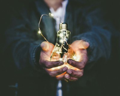 Light bulb in hands with LEDs illuminating